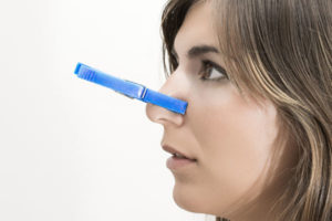 image of a woman covering nose from heating oil smell