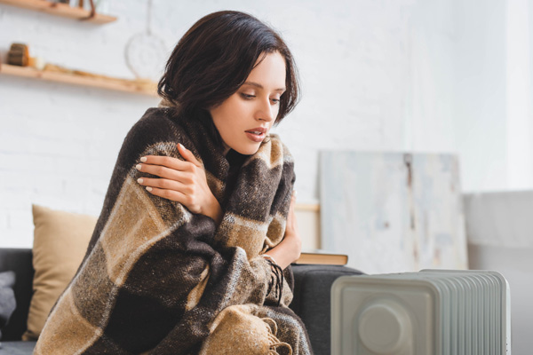 image of a homeowner keeping warm during a heating emergency