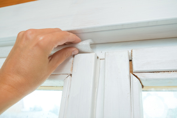 image of homeowner sealing air drafts