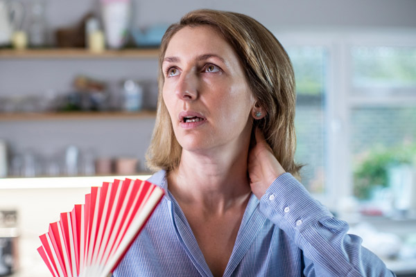 image of a homeowner using a fan to keep cool due to ac short cycling