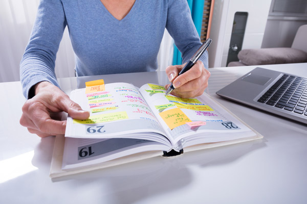 image of a woman writing in calendar depicting standby generator maintenance schedule