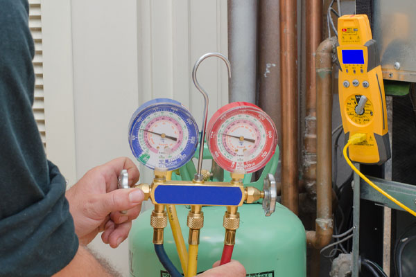 image of an hvac contractor checking ac refrigerant levels
