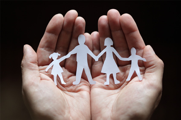 image of paper cut out of family in hands depicting furnace safety