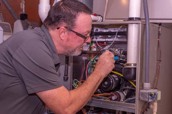image of an hvac tech fixing a gas furnace