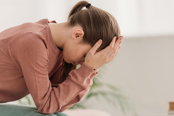 image of a woman with a headache due to poor indoor air quality