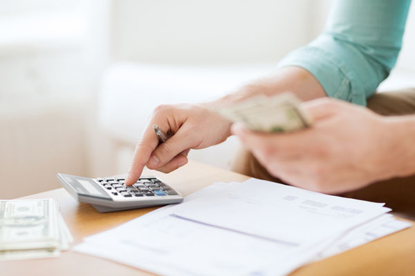 image of person calculating costs of a single vs double wall fuel oil tank