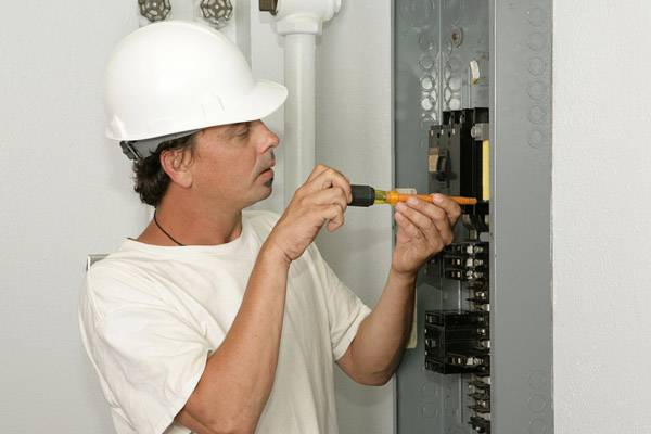 image of electrician repairing breaker box due to furnace breaker circuit