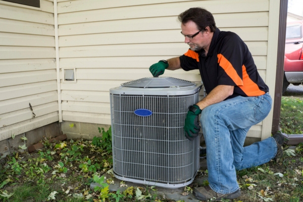 HVAC technician performing outdoor AC unit maintenance