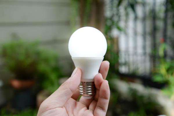 hand holding LED light depicting best practices for energy efficiency